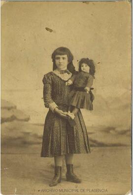Retrato de una niña con una muñeca en brazos