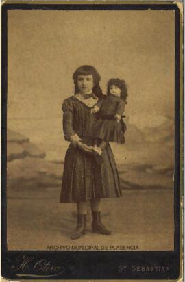 Retrato de una niña con una muñeca en brazos